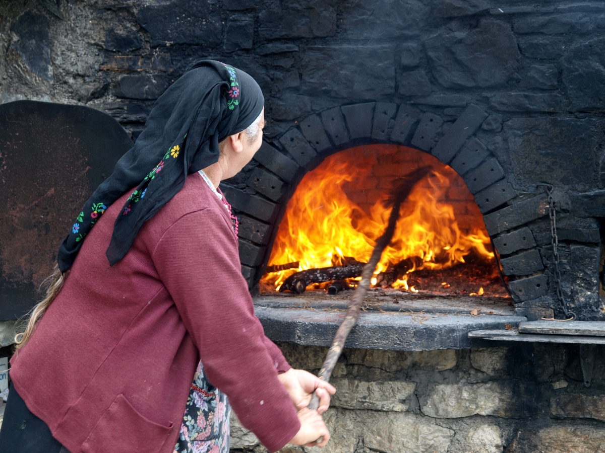 Η κυρία Καλλιόπη καίει τον παραδοσιακό φούρνο της στην Όλυμπο της Καρπάθου.